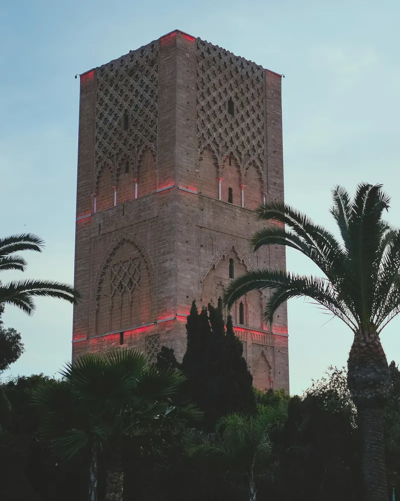 Hassan Tower at dusk, between the palm trees