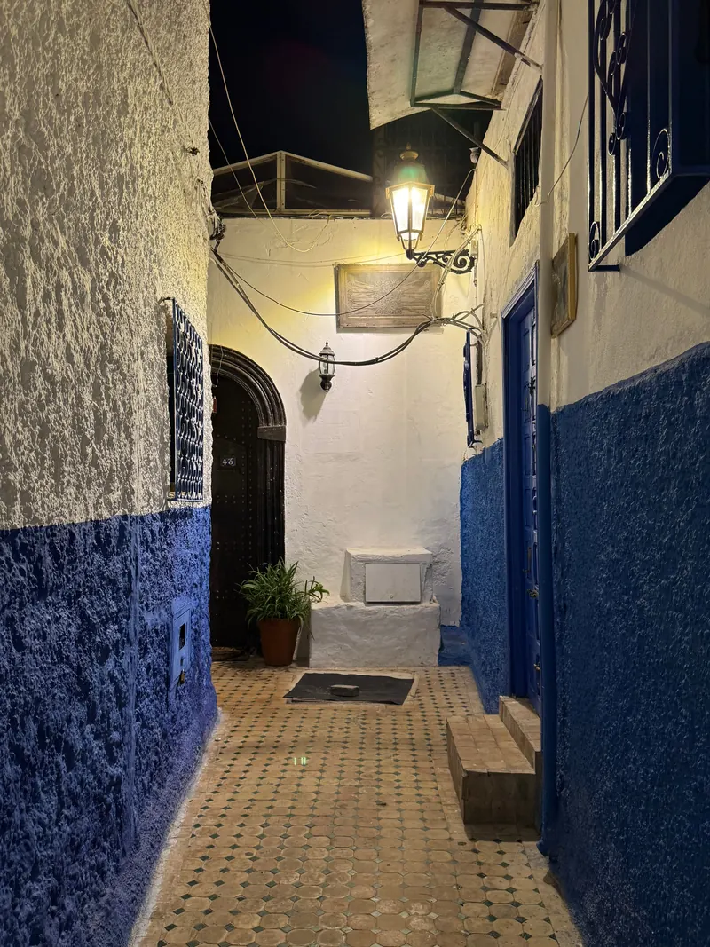 A blue street in the evening, lit by a lantern